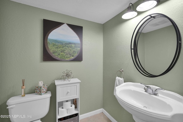 bathroom featuring sink, tile patterned floors, and toilet