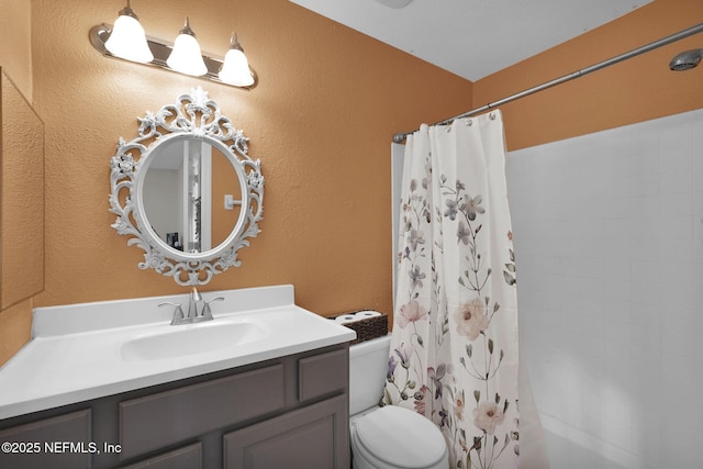 bathroom with toilet, vanity, and a shower with shower curtain