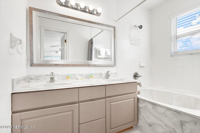 bathroom featuring tiled shower / bath combo and vanity