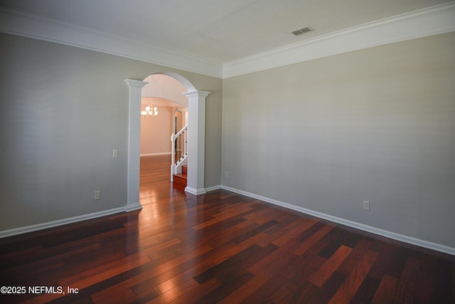 unfurnished room with decorative columns, crown molding, a notable chandelier, and dark hardwood / wood-style flooring