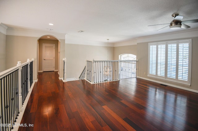 unfurnished room featuring crown molding, dark hardwood / wood-style floors, and a textured ceiling