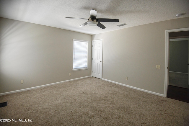 carpeted empty room featuring ceiling fan and a textured ceiling