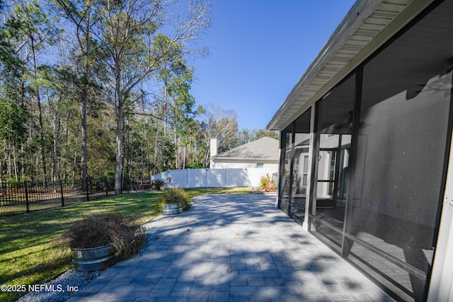 view of patio featuring ceiling fan and a sunroom