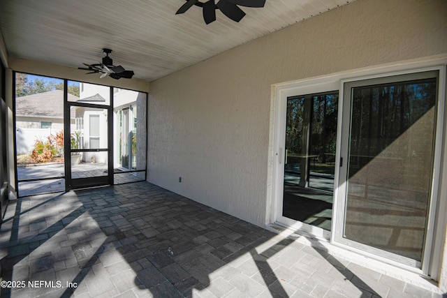 unfurnished sunroom with ceiling fan