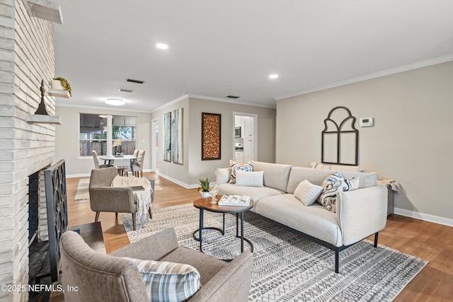 living room featuring ornamental molding, a brick fireplace, and hardwood / wood-style floors