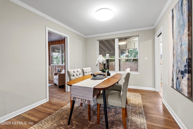 dining space with ornamental molding, plenty of natural light, and dark hardwood / wood-style floors