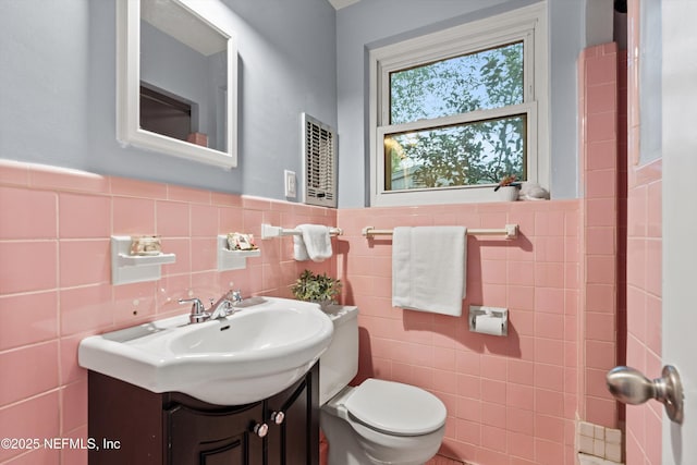 bathroom featuring vanity, tile walls, and toilet