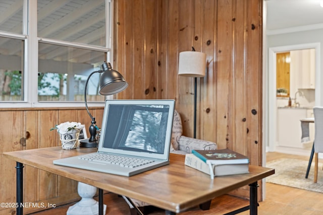 interior details with ornamental molding, wood-type flooring, and wood walls