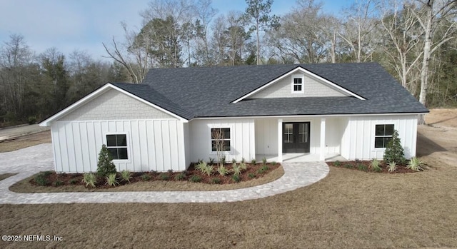 modern inspired farmhouse featuring board and batten siding, a shingled roof, and french doors