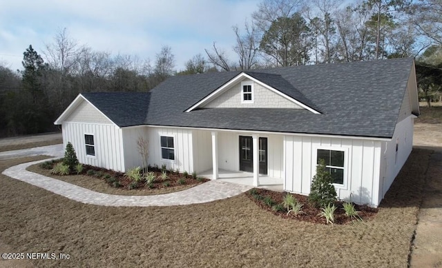 modern farmhouse style home with board and batten siding, a front lawn, and roof with shingles