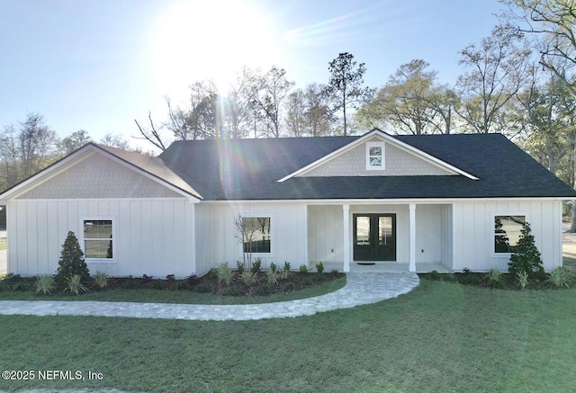 view of front of house featuring french doors, board and batten siding, and a front yard