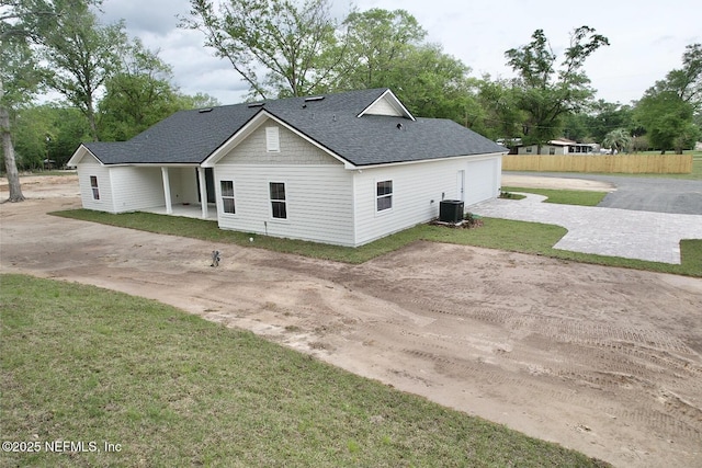 6141 Charlie Rowe Dr, Macclenny, FL 32063 - back of house featuring cooling unit, a lawn, driveway, a garage, and a shingled roof