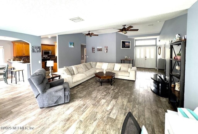 living room featuring ceiling fan and light wood-type flooring