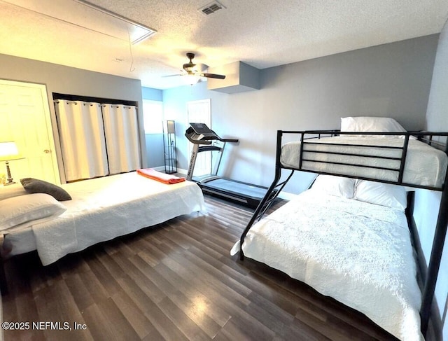 bedroom featuring ceiling fan, dark hardwood / wood-style floors, and a textured ceiling