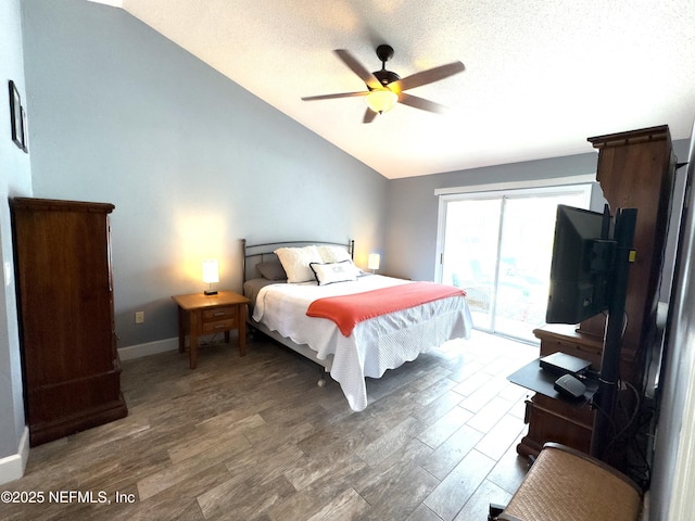 bedroom with vaulted ceiling, a textured ceiling, access to exterior, and dark hardwood / wood-style flooring