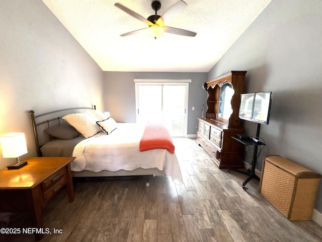 bedroom featuring lofted ceiling, access to exterior, ceiling fan, dark wood-type flooring, and a textured ceiling