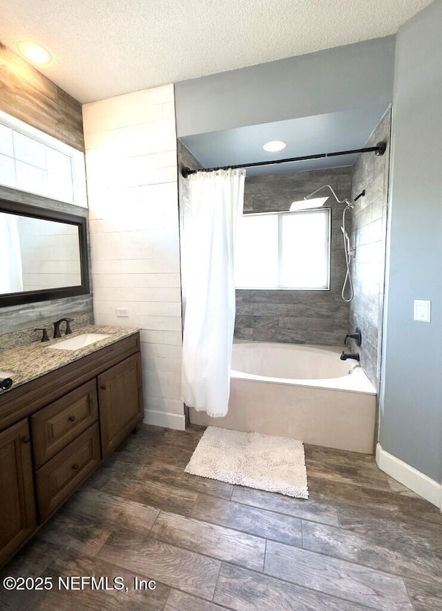 bathroom featuring vanity, shower / tub combo, hardwood / wood-style floors, and a textured ceiling