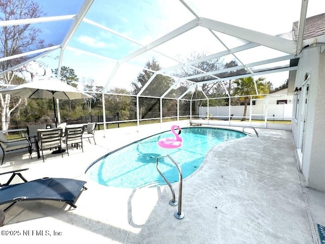 view of pool with a patio area and glass enclosure