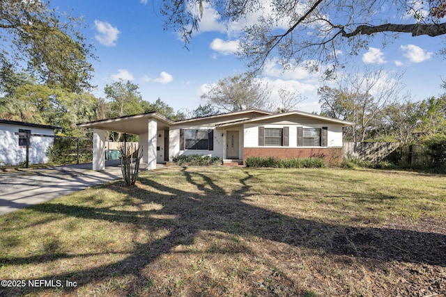 view of front of property with entry steps, an attached carport, brick siding, driveway, and a front yard