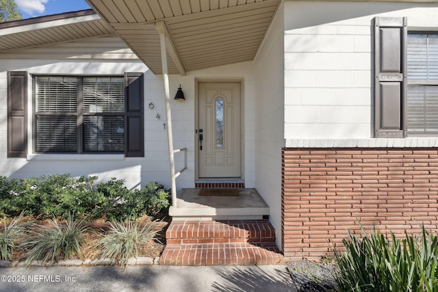 doorway to property featuring brick siding