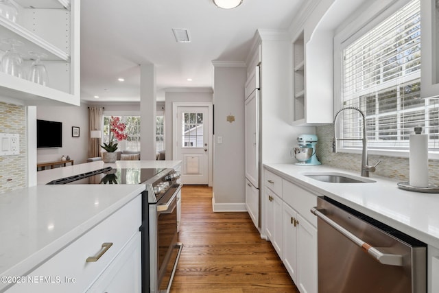 kitchen featuring white cabinets, appliances with stainless steel finishes, light countertops, and a sink