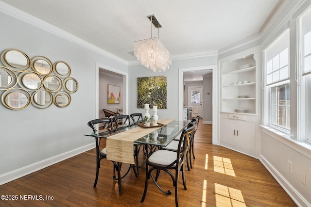 dining space featuring ornamental molding, a healthy amount of sunlight, baseboards, and wood finished floors