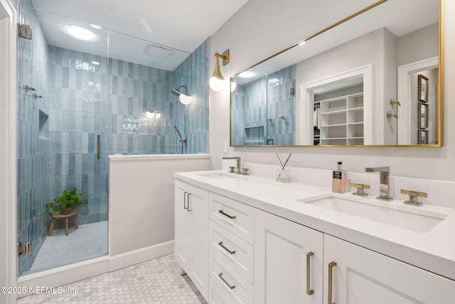 full bathroom featuring double vanity, a stall shower, a sink, and tile patterned floors