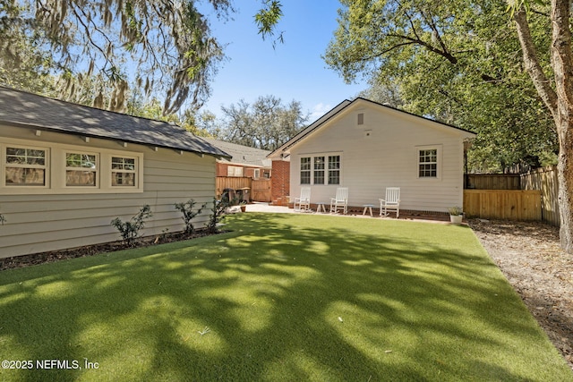 rear view of house with a patio area, fence, and a lawn