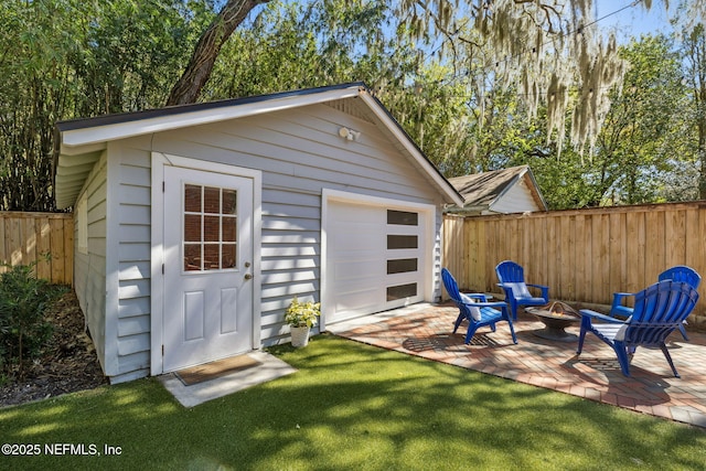 view of outdoor structure with an outdoor structure, a fire pit, and fence