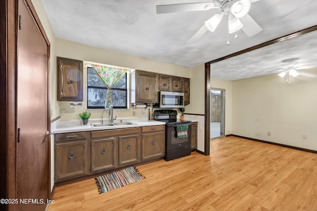 1019 Haynes Ct, Green Cove Springs, FL 32043 - kitchen with sink, ceiling fan, dark brown cabinetry, black electric range, and light wood-type flooring