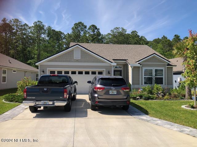 ranch-style home featuring a garage and a front yard