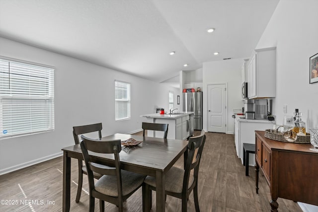 dining area with lofted ceiling, sink, and dark hardwood / wood-style flooring