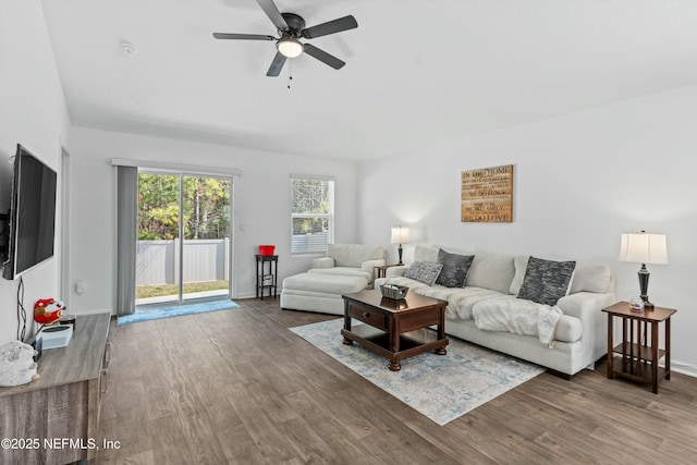 living room featuring dark wood-type flooring and ceiling fan