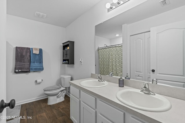 bathroom featuring walk in shower, vanity, toilet, and hardwood / wood-style floors