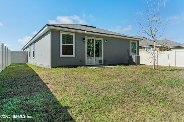 back of property featuring central AC and a yard