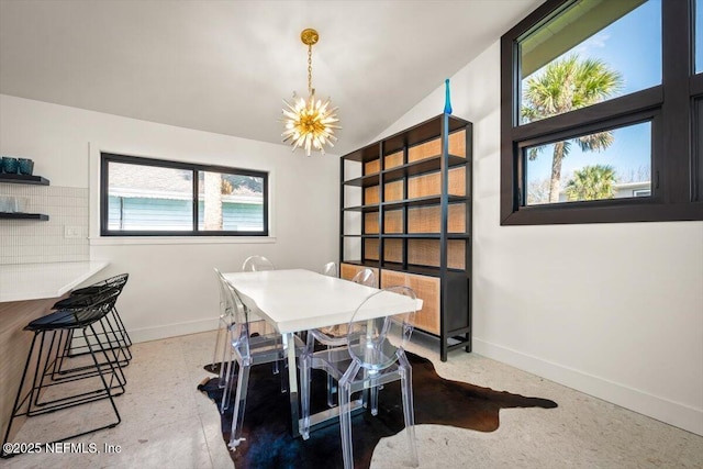 dining area featuring lofted ceiling and an inviting chandelier