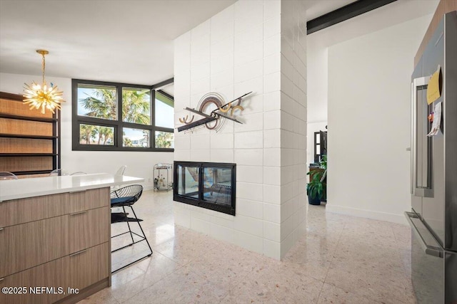 interior space featuring a tiled fireplace, tile walls, and an inviting chandelier