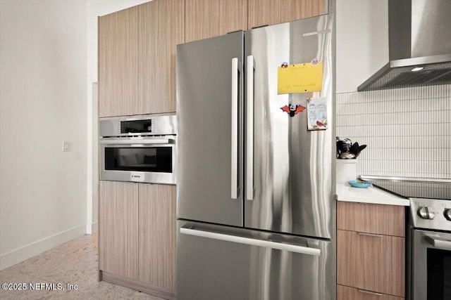 kitchen with appliances with stainless steel finishes and wall chimney range hood