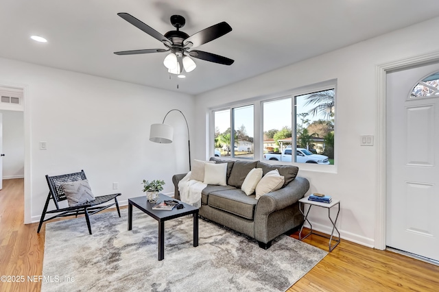 living room with wood-type flooring and ceiling fan