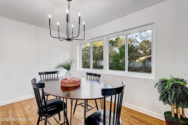 dining area featuring wood-type flooring and a notable chandelier