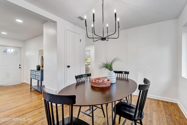 dining area featuring a chandelier and light wood-type flooring