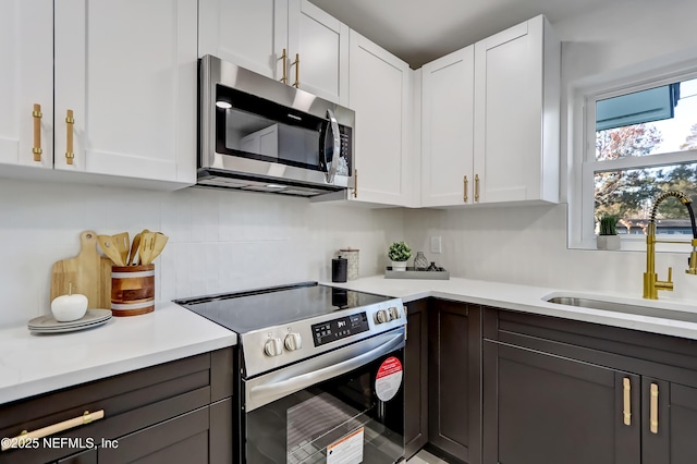 kitchen with sink, white cabinets, and appliances with stainless steel finishes