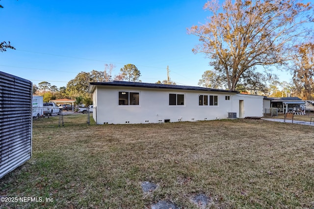 rear view of property featuring a yard and central AC unit