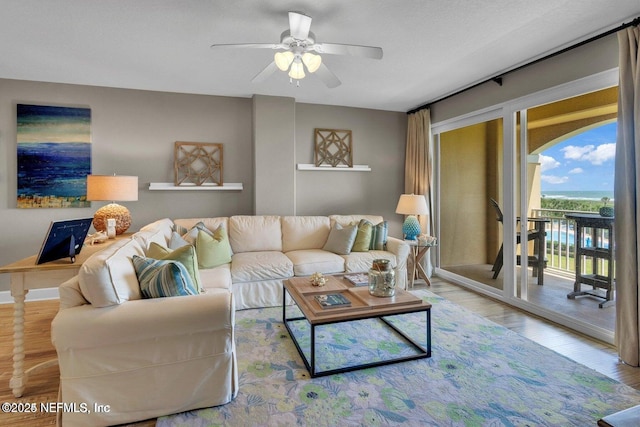 living room with light hardwood / wood-style flooring and ceiling fan