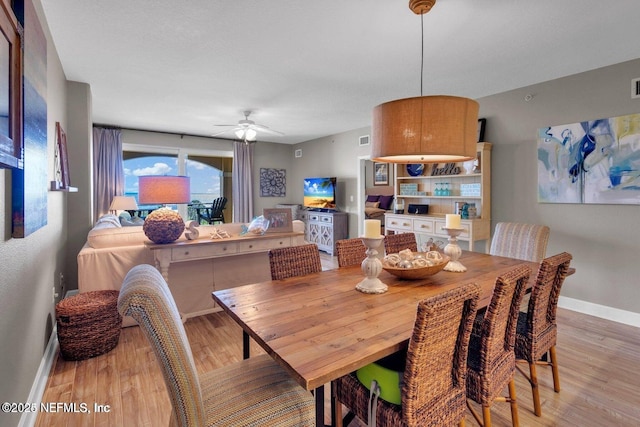 dining space with ceiling fan and light wood-type flooring