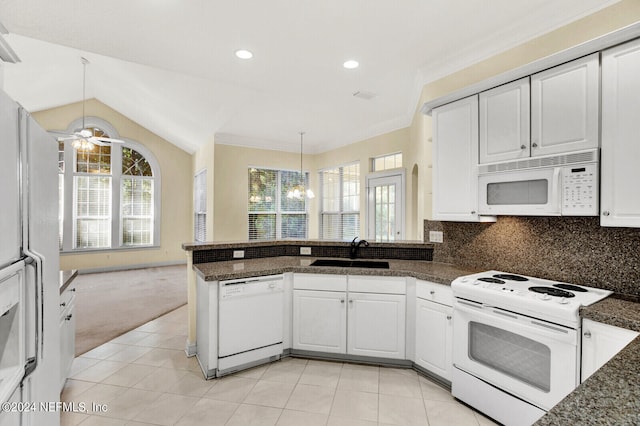 kitchen featuring a peninsula, white appliances, white cabinets, and a sink