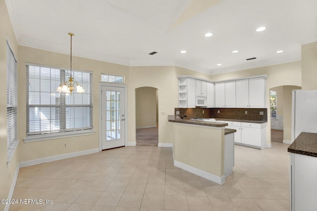 kitchen featuring arched walkways, white appliances, dark countertops, and open shelves