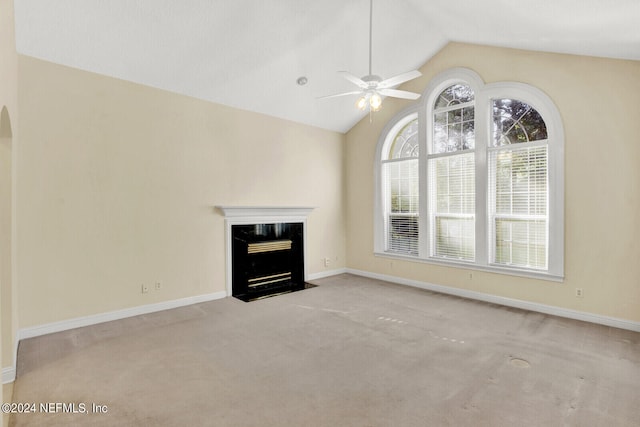 unfurnished living room with baseboards, a ceiling fan, lofted ceiling, a premium fireplace, and carpet floors