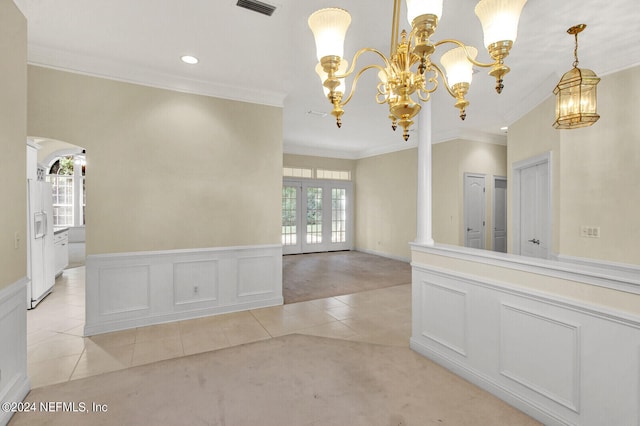 empty room with arched walkways, an inviting chandelier, french doors, a decorative wall, and light tile patterned flooring