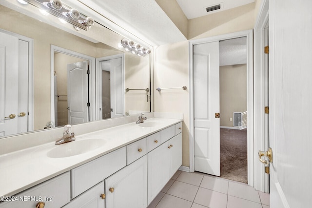 bathroom with double vanity, visible vents, a sink, and tile patterned floors